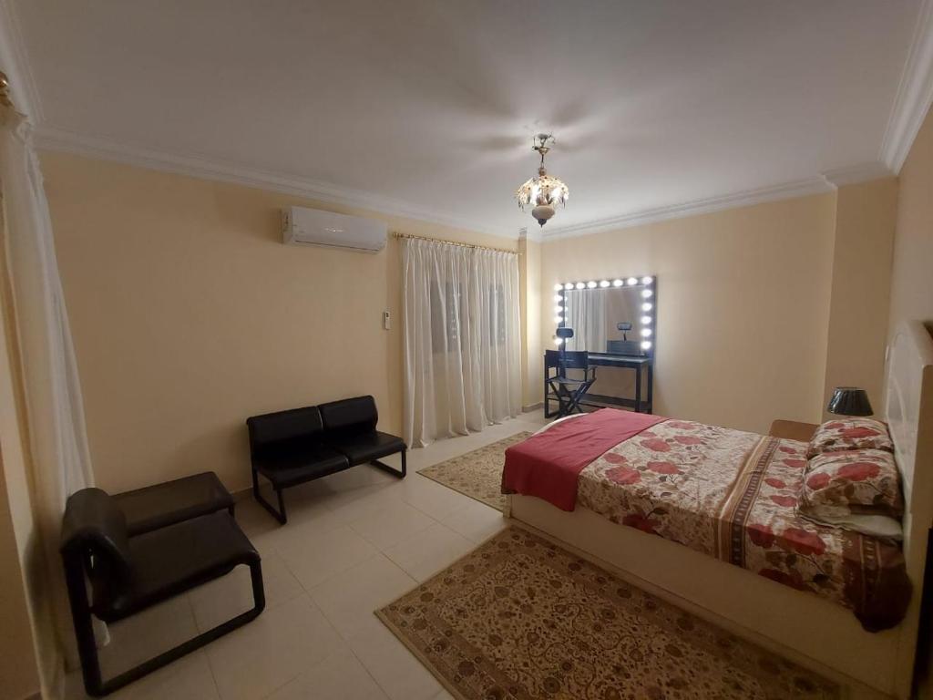 a bedroom with a bed and a chair in it at Duplex villa in 6th Of October