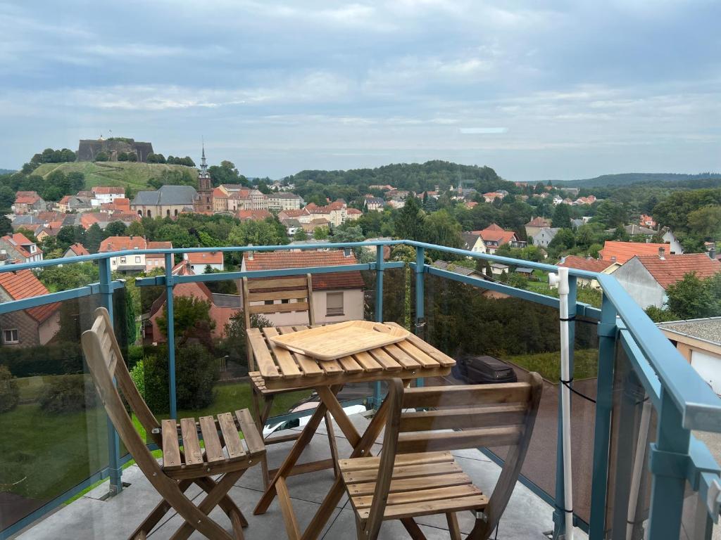 einen Tisch und Stühle auf einem Balkon mit Aussicht in der Unterkunft Appartement Nuage blanc in Bitche