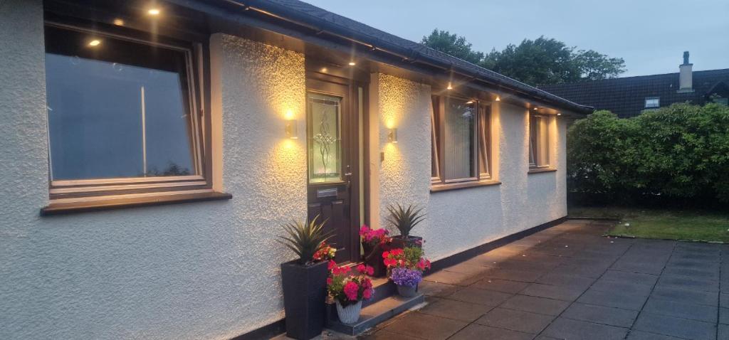 a house with flowers in front of a door at Hillend Self-Catering in Portree