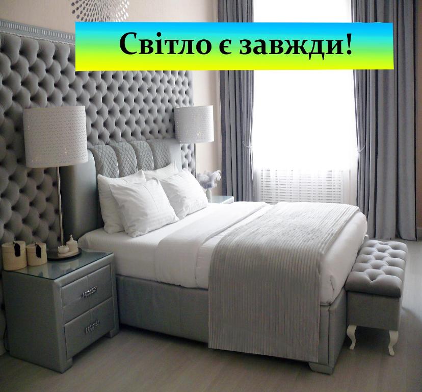 a bedroom with a large bed and a chair at Luxury Centre Located Apartment in Kyiv