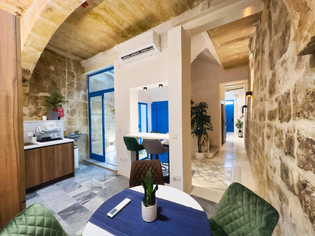 eine Küche und ein Wohnzimmer mit einem Tisch und Stühlen in der Unterkunft Mandera's Boutique Suites & Dorms in Valletta