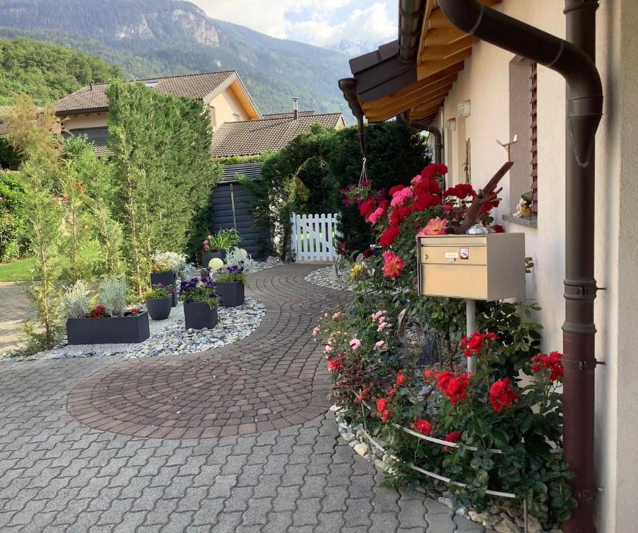 a brick walkway with flowers in pots next to a house at Ferienwohnung Lenggenhager Plantzette in Sierre
