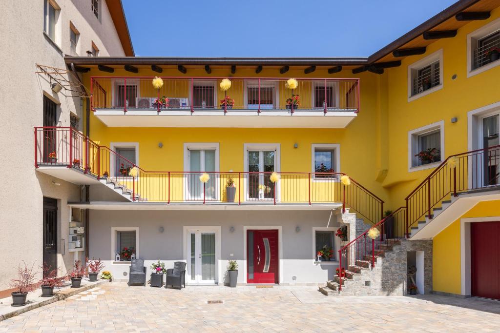 un edificio amarillo con balcones y una puerta roja en Vigna degli Angeli, en Ragogna