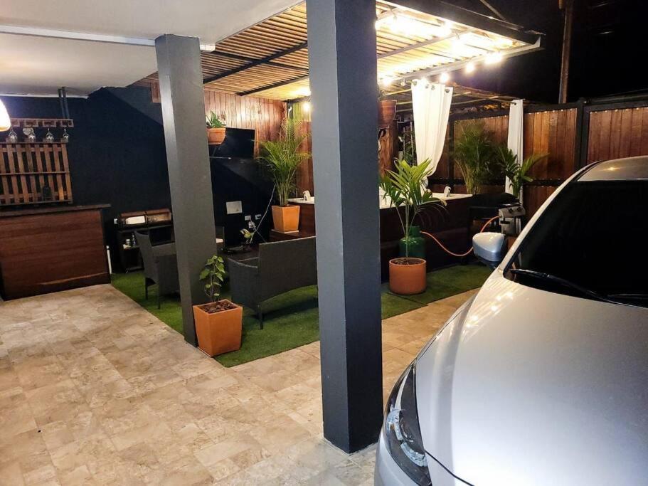 ein Auto, das in einem Wohnzimmer mit Topfpflanzen parkt in der Unterkunft Santani Casa de Descanso in Santa Fe de Antioquia