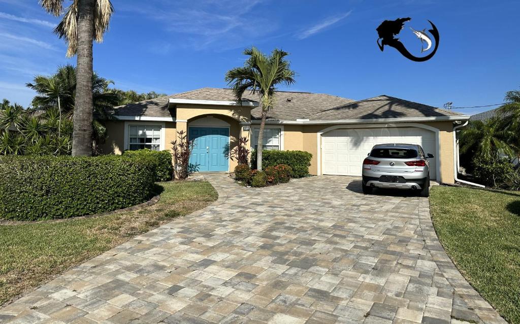 um carro estacionado em frente a uma casa com uma entrada em Mermaids & Marlins Private House & Pool em Cape Coral