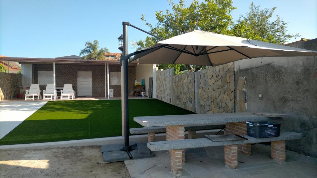 a picnic table with an umbrella in a backyard at Casa Alcabre (Samil) in Vigo