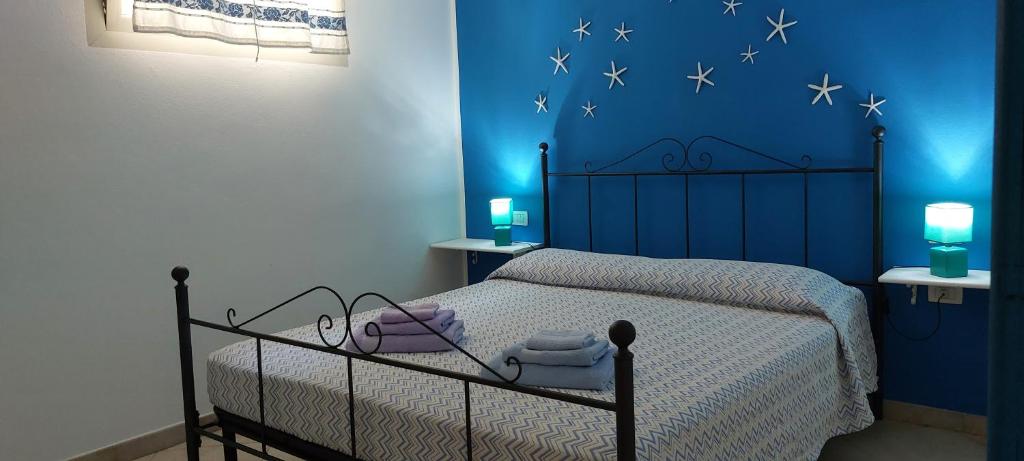1 dormitorio con 1 cama con una pared azul con estrellas en Casa Vacanze Laura en Tortolì