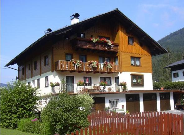 a large wooden house with balconies and a fence at Gästehaus Sams in Gosau