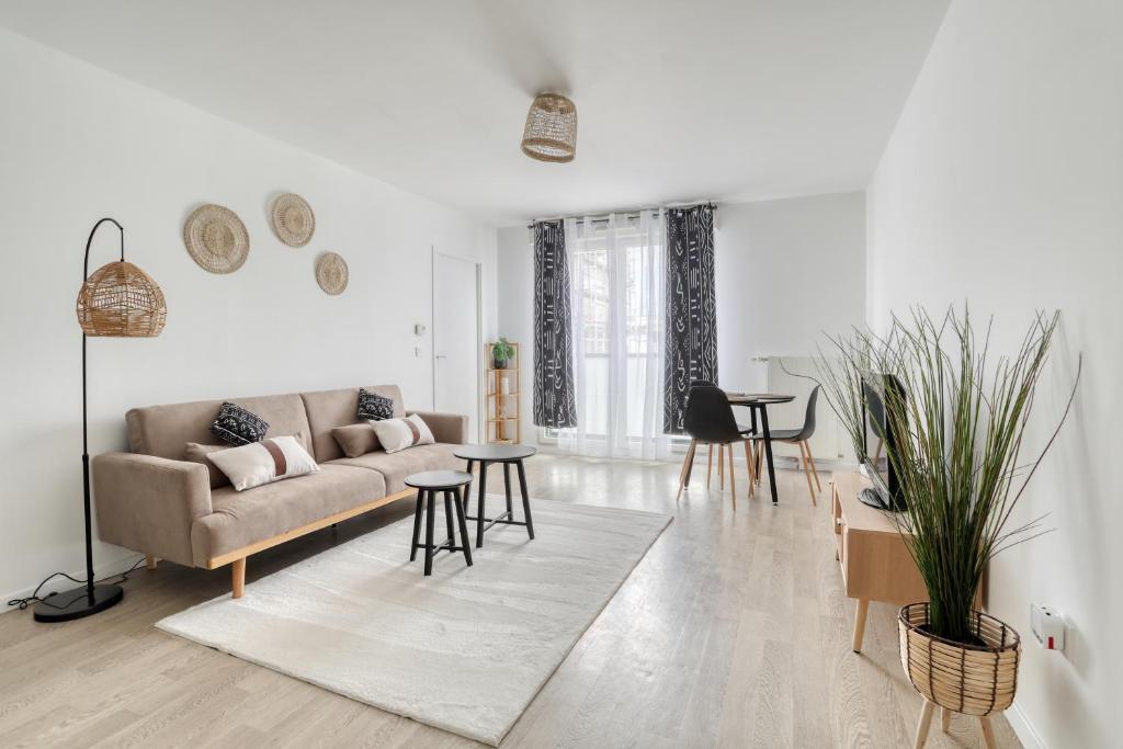 un salon avec un canapé et une table dans l'établissement L'Ethnic Print - Paris Stade de France, à Aubervilliers