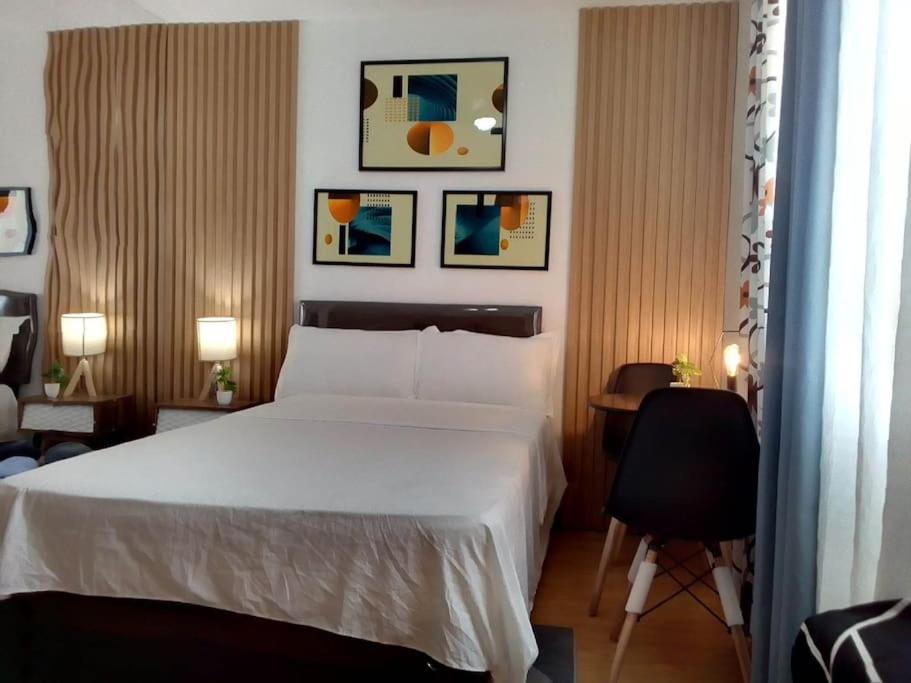 a bedroom with a bed and a desk with a chair at Affordable staycation @Mesaverte Residences cdo in Cagayan de Oro