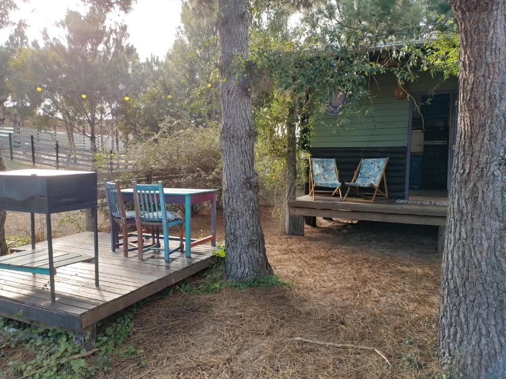 uma mesa e cadeiras num deque ao lado de uma árvore em la cabanita pinamar em Pinamar