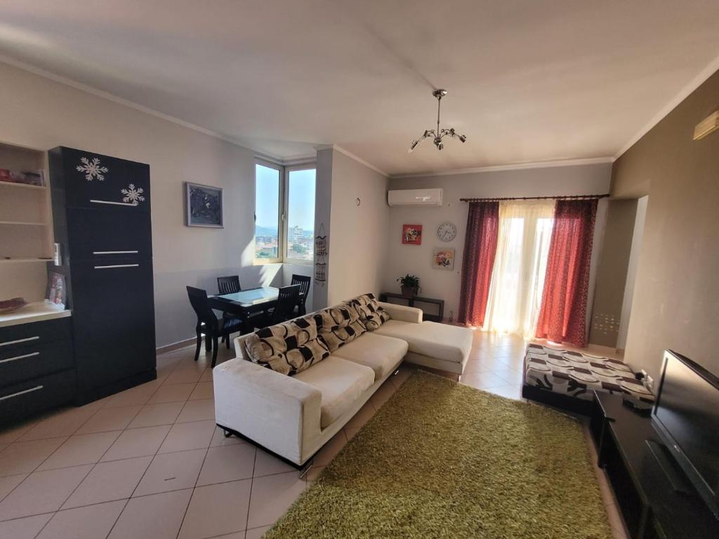 un soggiorno con divano bianco e tavolo di Nice and friendly apartment a Elbasan