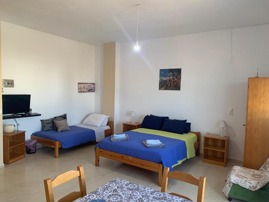 un soggiorno con 2 letti e un divano di Perivoli Guest Rooms a Kokkinos Pirgos