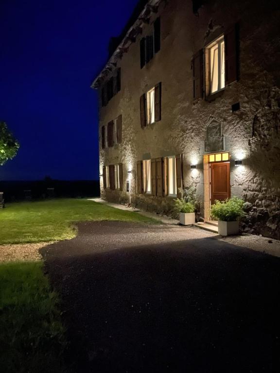 a large stone building with a door at night at Chateau de Cours in Sénezergues