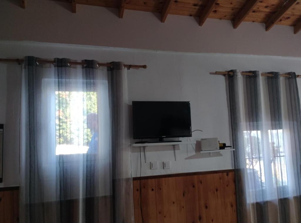 a room with a television and a window with curtains at Villa Απέραντο Γαλάζιο in Samothraki