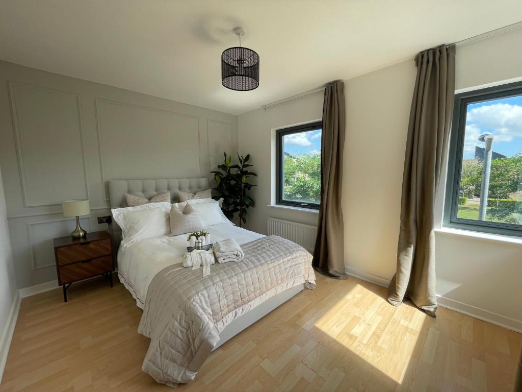 ein Schlafzimmer mit einem großen Bett mit zwei Handtüchern darauf in der Unterkunft Quiet Luxe Home with GYM and Free Parking in Thamesmead