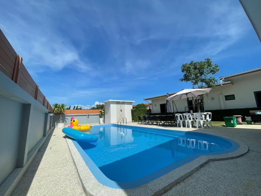 a swimming pool with a inflatable pool toy next to a house at The Memories Hill Phuket in Thalang