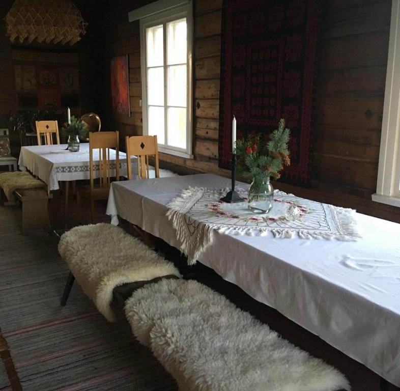 a dining room with a table with a white table cloth at Valkolan kartano, vanha tupa in Hankasalmi