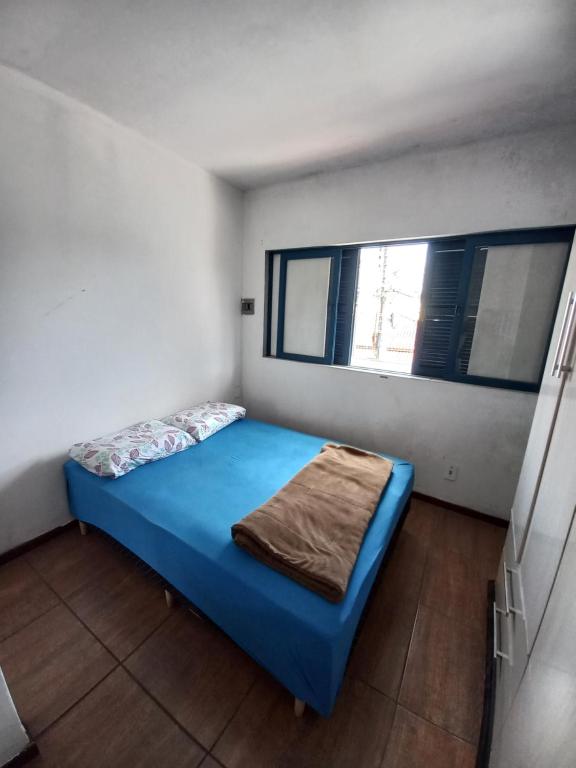 a bedroom with a blue bed and a window at Recanto Boa Vista in Joinville