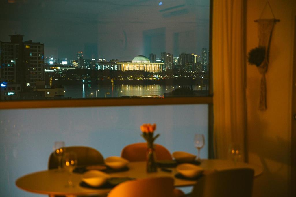 a dining room table with a view of a city skyline at Fall in the view in Seoul