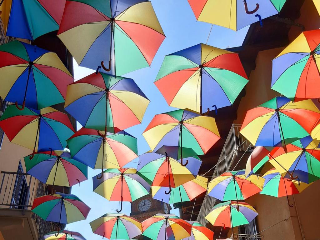 a bunch of colorful umbrellas hanging from a ceiling at Giaveno, apartment "margherita" a pochi passi dal centro, wifi in Giaveno