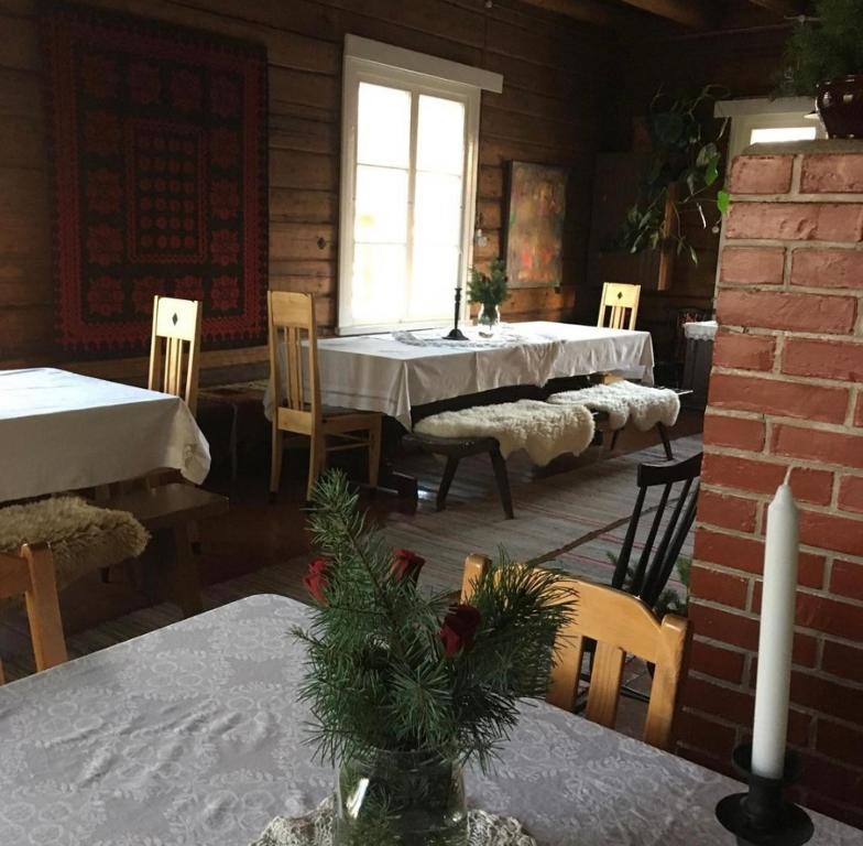 a dining room with a table and chairs in a cabin at Valkolan kartano, vanha tupa in Hankasalmi