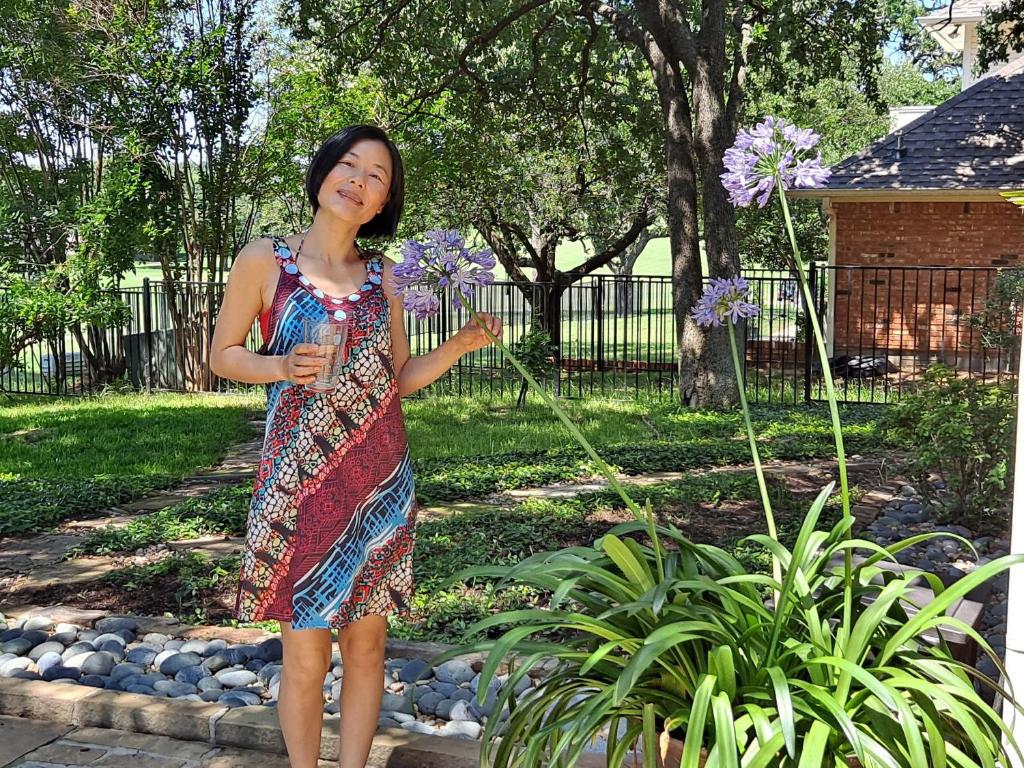 a woman in a dress holding purple flowers at Golden Sunflower's Apt A in Lawton