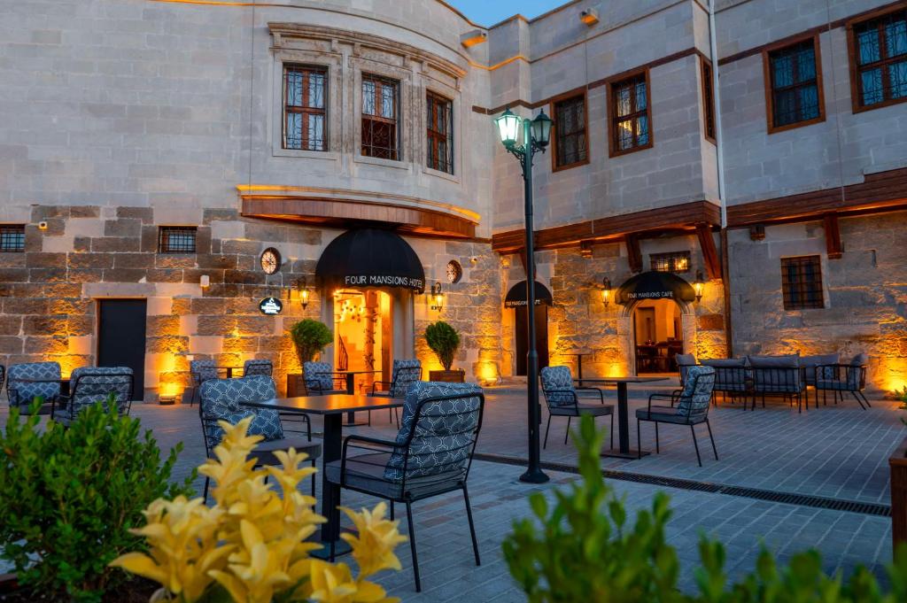 a patio with tables and chairs in front of a building at Four Mansions Hotel in Kayseri