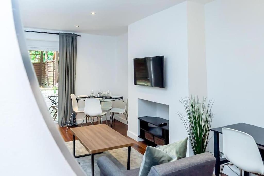 a living room with a couch and a table at Hidden Gem with En-Suites in West Hampstead in London