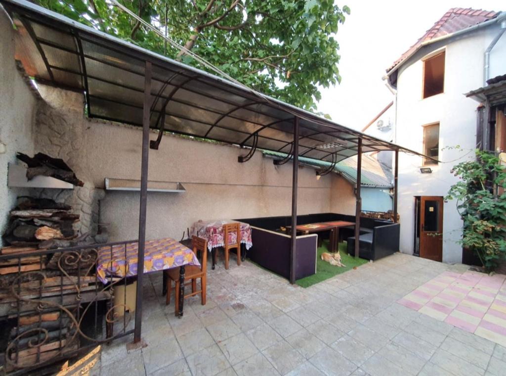 un patio con mesa y sillas bajo toldo en Genius Hostel Center with Grill zone and yard en Chişinău