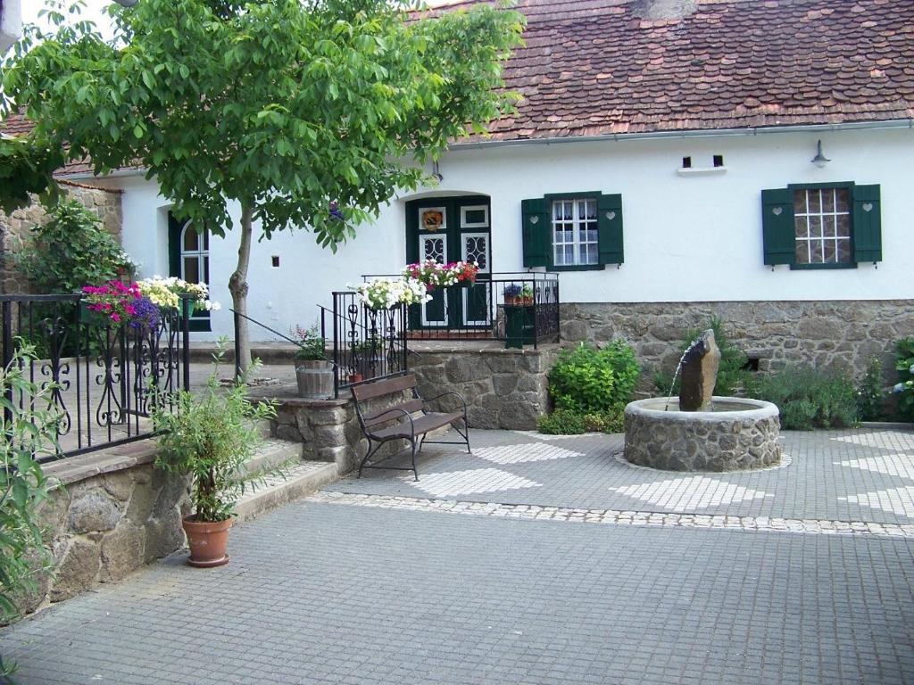 ein Haus mit einer Bank und einem Brunnen davor in der Unterkunft Apartment Liendl in Riegersburg