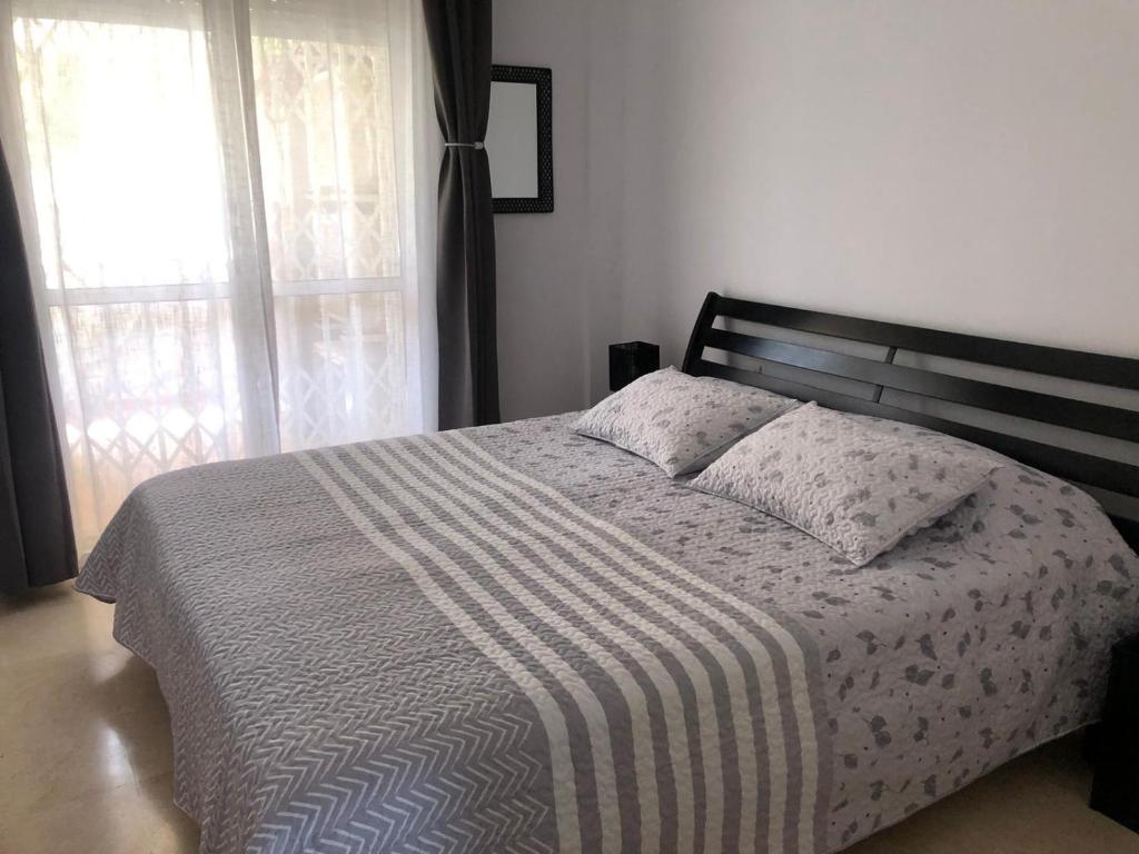 sypialnia z łóżkiem z paskiem i oknem w obiekcie Apartment Costa del Sol, Manilva, Duquesa w mieście Castillo de Sabinillas