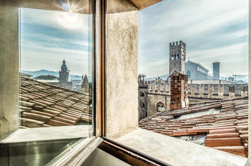 ein offenes Fenster mit Stadtblick in der Unterkunft Casa Calypso in Canton de' Fiori in Bologna