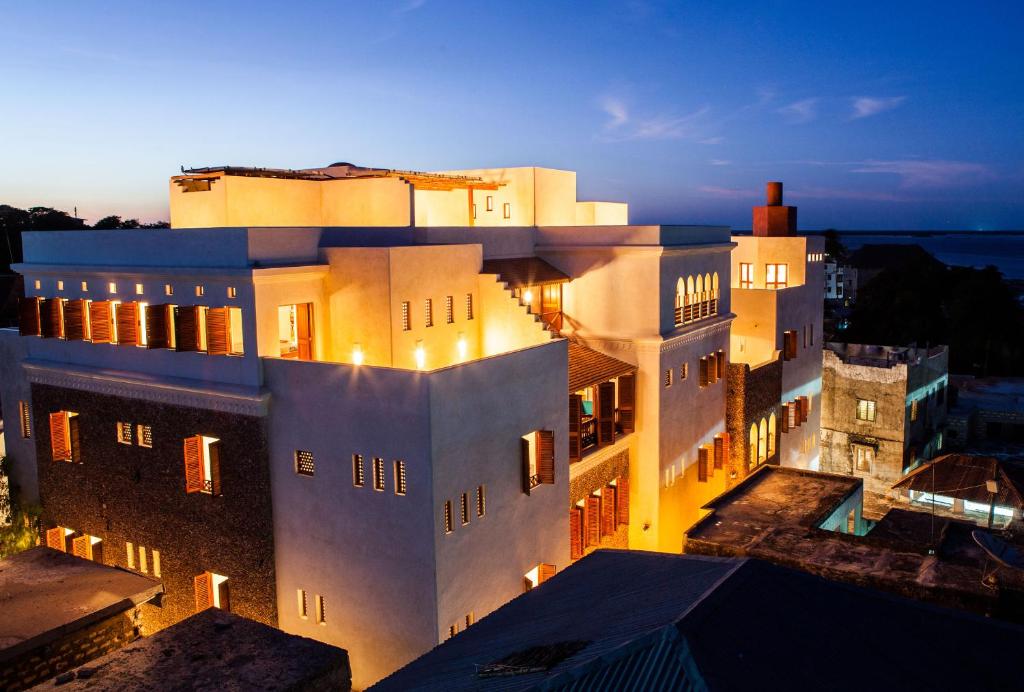 a large white building with lights on at Swahili Dreams Apartments in Lamu
