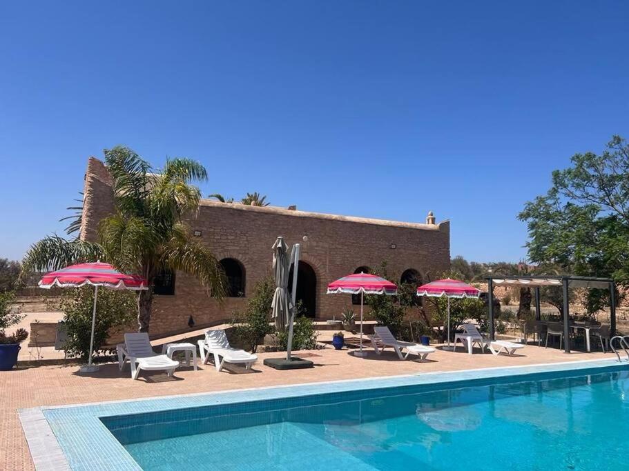 - une piscine avec des chaises et des parasols à côté d'un bâtiment dans l'établissement Villa Essaouira, à Essaouira