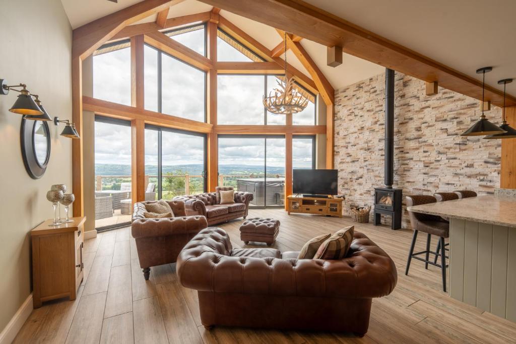 a living room with leather furniture and a large window at Valley View Luxury Lodges Gamekeepers 4 Bedroomed in Preston