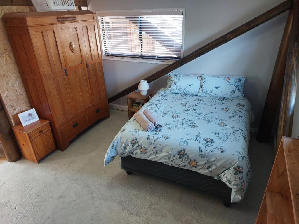 a bedroom with a bed and a wooden dresser at Penelope Selfcatering Apartment in Wilderness