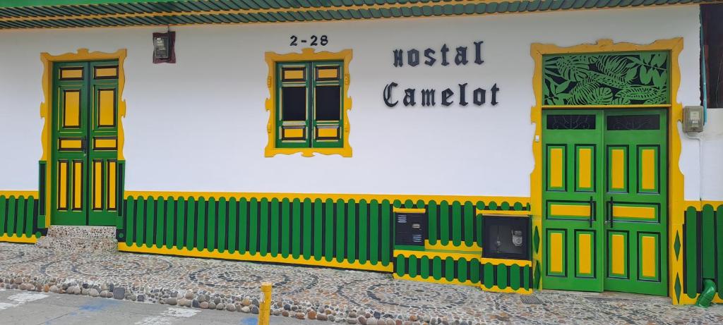 un edificio con puertas verdes y amarillas. en Hostel Camelot Salento en Salento