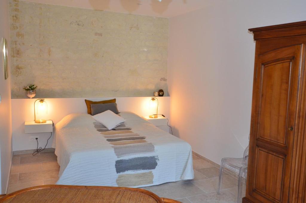 Thizay的住宿－Chambre Gargantua Le dolmen，一间卧室配有一张带两盏灯的大型白色床。