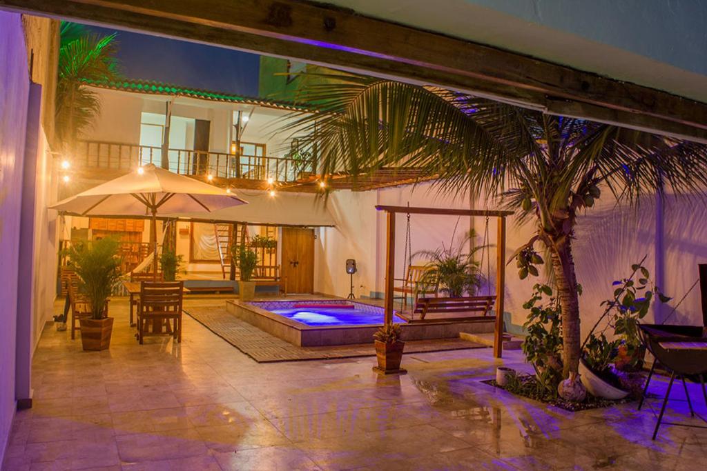 a house with a swimming pool and a palm tree at HOSTAL LA BOQUILLA in Cartagena de Indias