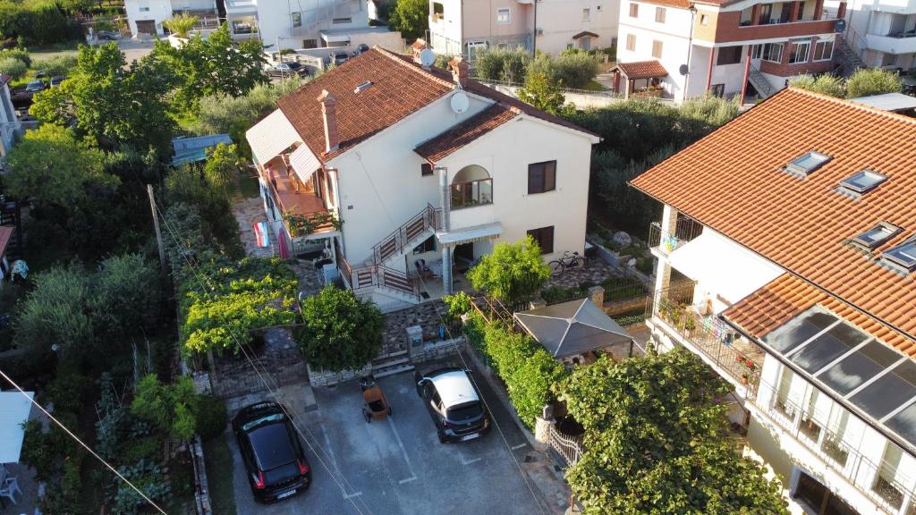 una vista aérea de una casa con coches aparcados en un aparcamiento en Apartments Reinić, en Novigrad Istria