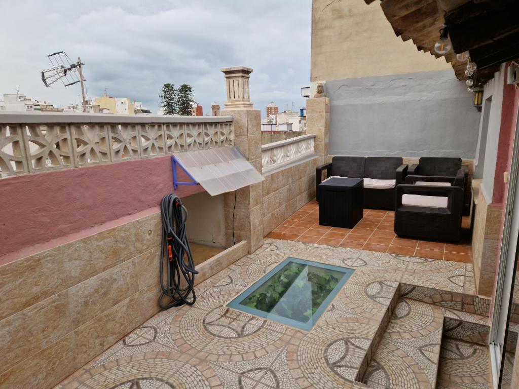 a balcony with a glass table and a couch at Casa con terraza a 10min de la playa in Cullera