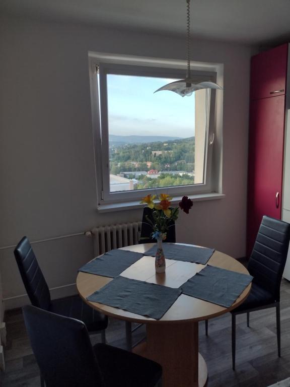 a dining room with a table and chairs and a window at Apartmán Uvalská in Karlovy Vary