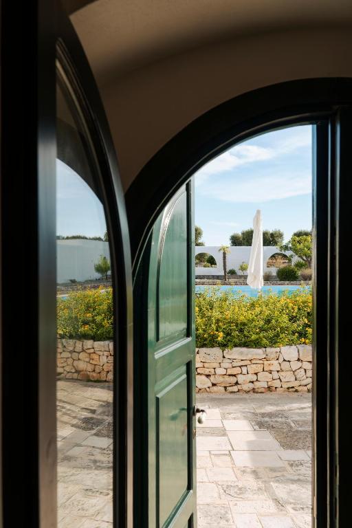 an open door with a view of a pool at Masseria Gorgognolo in Ostuni