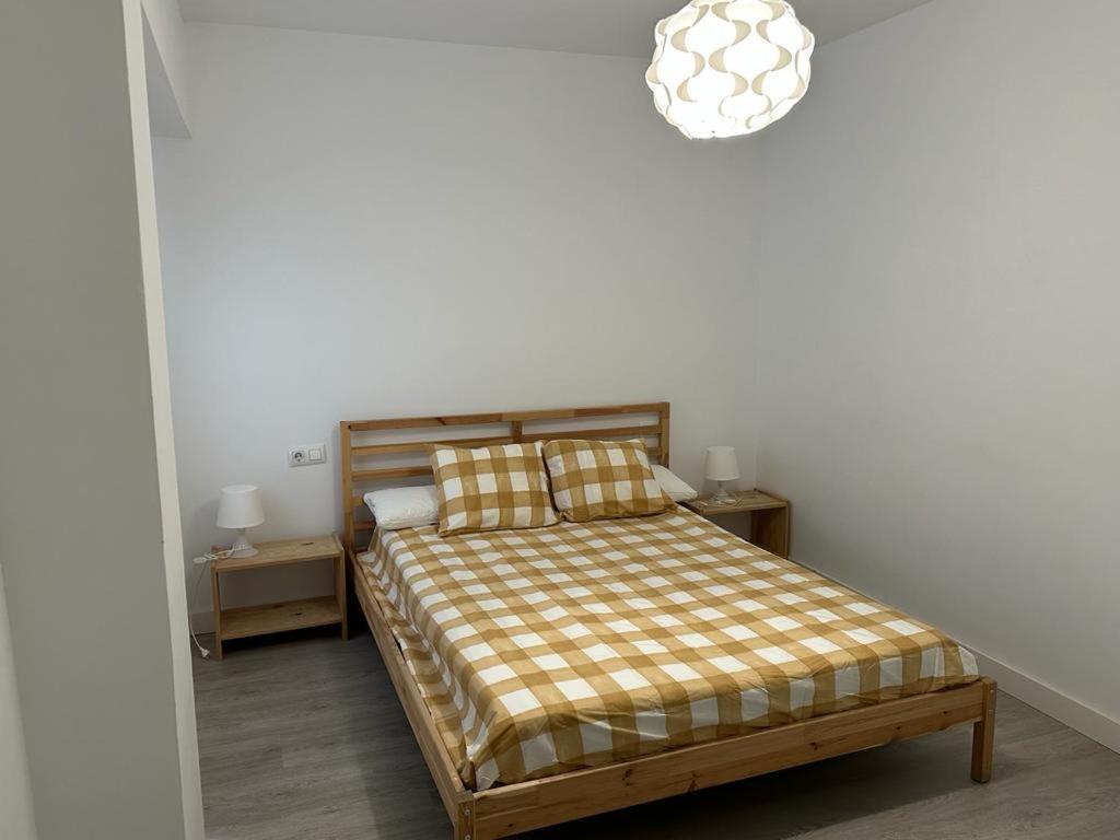 um quarto com uma cama e um lustre em Ameyal Madre Rafols em Sevilha
