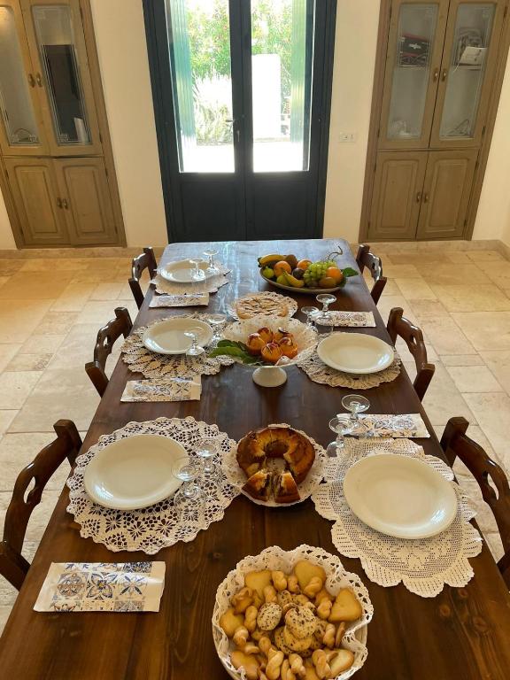 a wooden table with plates and food on it at Masseria Gorgognolo in Ostuni