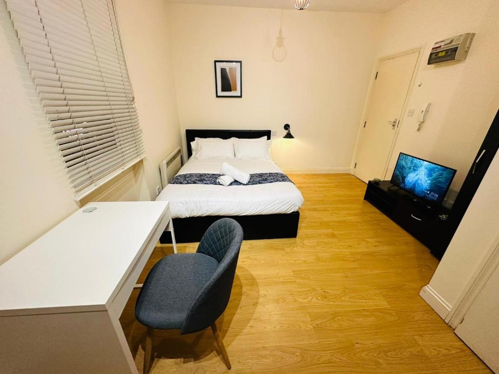 a bedroom with a bed and a desk and a television at Premium Studio Flat 05 Near Tower Bridge in London