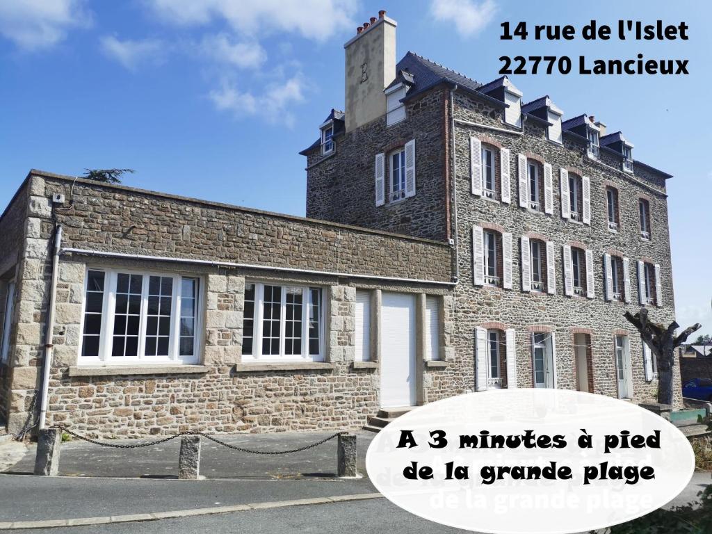 an old brick building with a clock tower on top at Gîte des trois plages 6 personnes in Lancieux