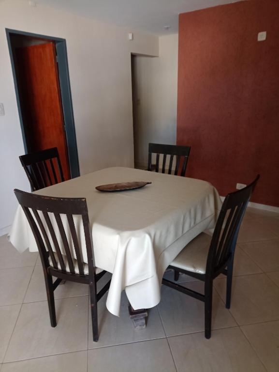 mesa de comedor con sillas y mantel blanco en Esquina Apart en Alta Gracia