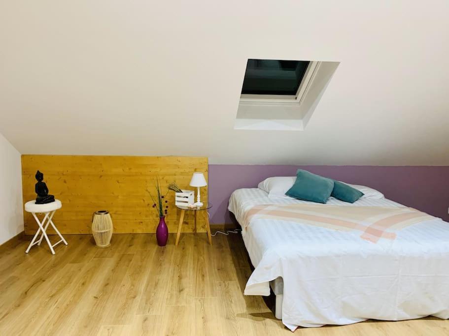 um quarto com 2 camas e piso em madeira em Gîte Cosy au cœur de l'Alsace em Roggenhouse